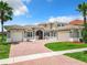 Two-story house with tile roof, large windows, and a brick driveway at 870 Spinnaker Way, Kissimmee, FL 34746