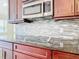 Modern kitchen features with stainless steel microwave and cooktop at 870 Spinnaker Way, Kissimmee, FL 34746
