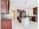 Spacious kitchen featuring dark wood cabinetry, granite island, and tile flooring at 870 Spinnaker Way, Kissimmee, FL 34746