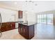 Kitchen with island, granite countertops, and view to backyard through sliding doors at 870 Spinnaker Way, Kissimmee, FL 34746