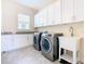 Bright laundry room with white cabinets and granite countertops at 870 Spinnaker Way, Kissimmee, FL 34746