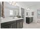Double vanity bathroom with dark cabinets and a walk-in shower at 8870 Backspin Ln, Champions Gate, FL 33896