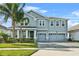 Two-story house with gray siding, three-car garage, and landscaped yard at 8870 Backspin Ln, Champions Gate, FL 33896