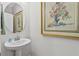 Charming powder room with pedestal sink and art at 8870 Backspin Ln, Champions Gate, FL 33896