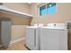 Convenient laundry room with washer, dryer, and shelving at 7537 Brooklyn Dr, Kissimmee, FL 34747