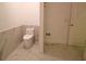 Modern bathroom features tiled floor, toilet, and marble-look shower with glass door at 10001 Newington Dr, Orlando, FL 32836