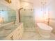 Bright bathroom with a soaking tub, glass shower, and marble countertop vanity at 10001 Newington Dr, Orlando, FL 32836