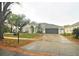 House exterior featuring a two-car garage and well-manicured lawn at 10001 Newington Dr, Orlando, FL 32836