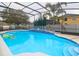 Sparkling screened-in pool with blue tile accents and decorative potted greenery at 10001 Newington Dr, Orlando, FL 32836