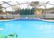 Inviting swimming pool with a screened enclosure and lush landscaping at 10001 Newington Dr, Orlando, FL 32836
