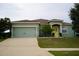 One-story house with a two-car garage and a yellow front door at 1028 Merrimack Blvd, Davenport, FL 33837