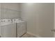 Bright laundry room with washer, dryer, and overhead shelving at 10425 Folly Beach Rd, Orlando, FL 32827