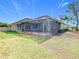 Large backyard with screened patio and grassy area at 125 Viola Dr, Auburndale, FL 33823