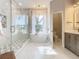 Spa-like bathroom with a large walk-in shower, soaking tub, and marble finishes at 125 Viola Dr, Auburndale, FL 33823