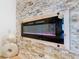 Modern electric fireplace with stone surround and sleek wooden frame at 125 Viola Dr, Auburndale, FL 33823