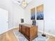 Home office with large wooden desk, light walls, and hardwood floors at 125 Viola Dr, Auburndale, FL 33823