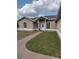 Charming single-story home with well-maintained lawn and brick walkway leading to front door at 149 Birmingham Dr, Kissimmee, FL 34758