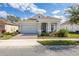 Charming single-story home features a brick driveway, manicured lawn, and a covered front porch with decorative columns at 2051 Flora Pass Pl, Kissimmee, FL 34747