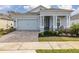 Gray house with a light gray garage door, white columns, and a landscaped front yard at 2051 Flora Pass Pl, Kissimmee, FL 34747