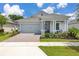 Charming single-story home featuring a two-car garage, covered porch with columns, and a well-manicured front lawn at 2051 Flora Pass Pl, Kissimmee, FL 34747