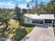 Single-story home with metal roof, large yard, and a spacious driveway leading to a screened-in porch at 2601 16Th St, St Cloud, FL 34769