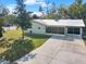 Well-maintained single-story home with a metal roof, screened porch, and a spacious driveway at 2601 16Th St, St Cloud, FL 34769