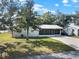 Exterior view of a house featuring a metal roof, well-kept lawn, and a screened-in porch at 2601 16Th St, St Cloud, FL 34769