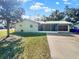 Well-maintained single-story home with a metal roof, screened porch, and a spacious driveway at 2601 16Th St, St Cloud, FL 34769