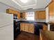 Well-lit kitchen with wooden cabinets, black appliances, and a view from the window at 2601 16Th St, St Cloud, FL 34769