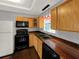 Charming kitchen with wood cabinets, black appliances, and modern sink at 2601 16Th St, St Cloud, FL 34769