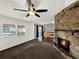 Bright living room showcasing a stone fireplace, ceiling fan, and natural light at 2601 16Th St, St Cloud, FL 34769