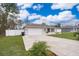 House exterior showcasing a driveway and fenced yard at 3 Pecan Drive Loop, Ocala, FL 34472