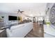 Open living area with gray sofa, hardwood floors, and kitchen view at 3 Pecan Drive Loop, Ocala, FL 34472