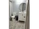 Updated bathroom features a modern vanity, round mirror, and neutral color palette at 345 Forestway Cir # 106, Altamonte Springs, FL 32701