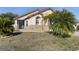 Tan house with palm trees and a small patio at 4525 Oakbrook Ct, Kissimmee, FL 34746