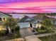 Aerial sunset view of house by lake at 4540 Sequel Rd, Kissimmee, FL 34746
