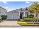 Two-story home with gray exterior, two-car garage, and landscaped front yard at 4540 Sequel Rd, Kissimmee, FL 34746