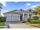 Two-story home with gray exterior, two-car garage, and landscaped yard at 4540 Sequel Rd, Kissimmee, FL 34746