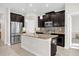 Modern kitchen with dark cabinets, granite countertops, and stainless steel appliances at 4540 Sequel Rd, Kissimmee, FL 34746