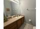 Cozy bathroom with a single vanity, framed mirror, and neutral color scheme at 4557 Ada Ln, Kissimmee, FL 34746