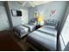 Clean bedroom featuring two twin beds, tv, and gray striped bedding at 4557 Ada Ln, Kissimmee, FL 34746