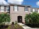 Charming two-story townhome featuring a beautiful stucco facade, landscaped yard, and a welcoming entrance at 4557 Ada Ln, Kissimmee, FL 34746