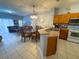 Open-concept kitchen and dining area featuring modern appliances, tiled floors, and a seamless flow to the living space at 4557 Ada Ln, Kissimmee, FL 34746