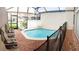 Screened-in pool area with lounge chairs and black safety fence at 4557 Ada Ln, Kissimmee, FL 34746