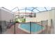 Relaxing screened-in pool area with brick flooring, lounge chairs, and black safety fence at 4557 Ada Ln, Kissimmee, FL 34746
