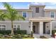 Two-story townhome with gray exterior, palm tree, and landscaping at 4818 Memories Ln, Kissimmee, FL 34746