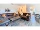 Open living space with leather sofas, wood-look floors, and views to dining area at 540 Hunter Cir, Kissimmee, FL 34758