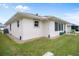 Single-story house with light-colored siding, a paved patio, and a well-maintained lawn at 580 Teesdale, Haines City, FL 33844