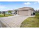 Tan house with attached garage and paved driveway, set back from the street with landscaping at 580 Teesdale, Haines City, FL 33844