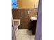 Tiled half bathroom featuring toilet with matching purple seat cover and a pedestal sink at 704 N 8Th St, Haines City, FL 33844